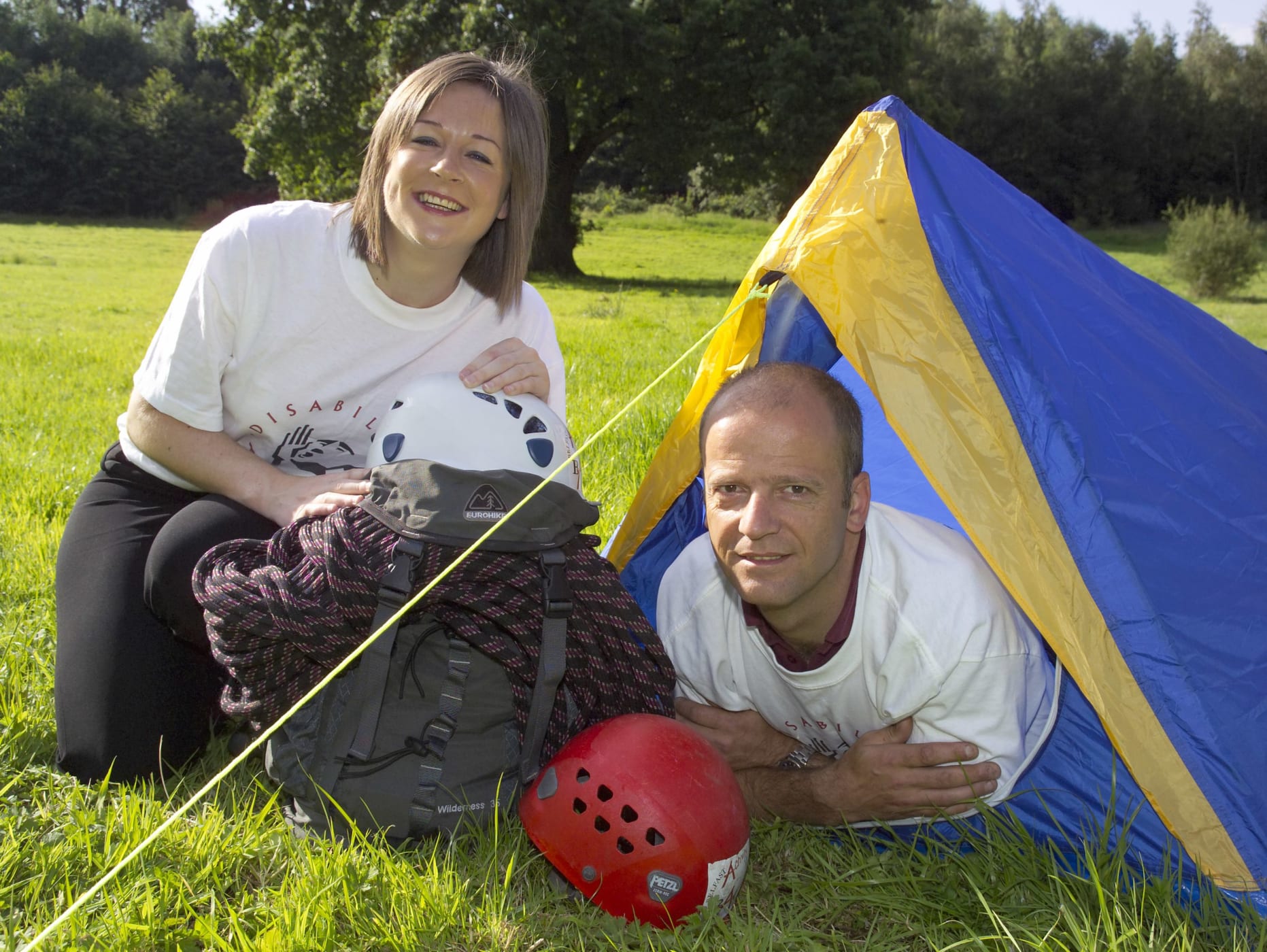 Image of Darren Campbell in a tent and Clare Sheeran from Disability Action in a Disability Action t-shirt